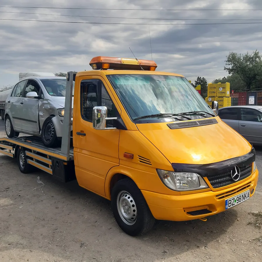 Autoturism încărcat pe platforma de tractare
